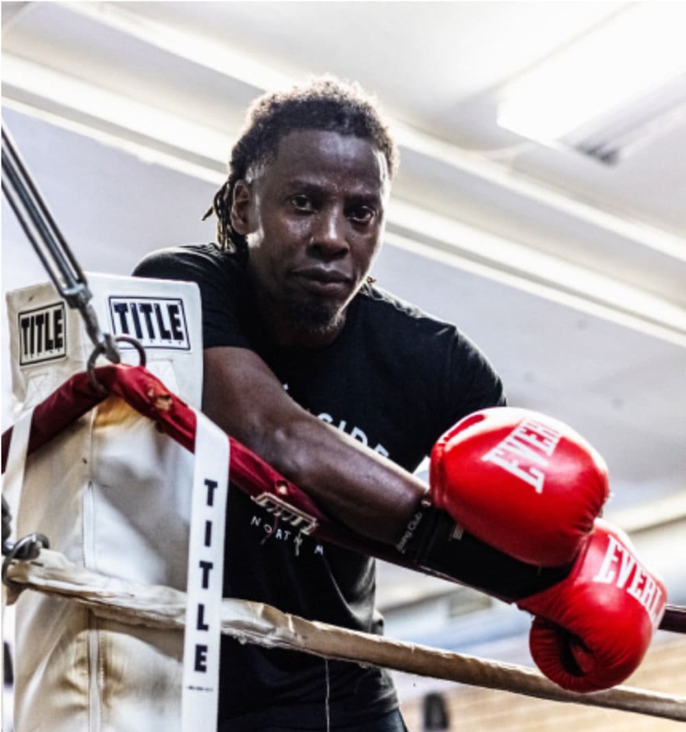 Photo of Moe Kayongo in the ring with boxing gloves on.